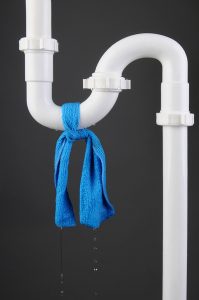 plastic pipe with blue cloth tied around it to stop a leak