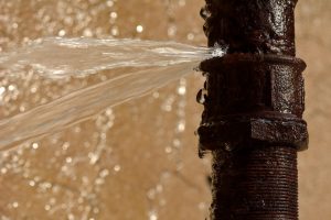 old rusty pipe with pinhole leak