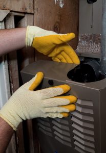 technicians gloved hands repairing heater