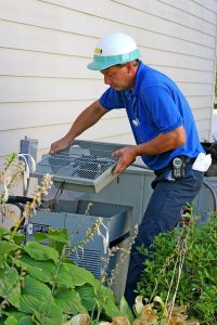 male technician working on outside AC unit