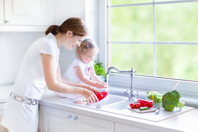 family-standing-over-kitchen-sink