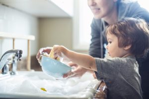 parent-and-toddler-washing-dishes-together