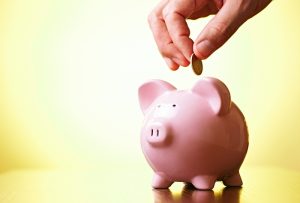 hand-dropping-coin-into-piggy-bank